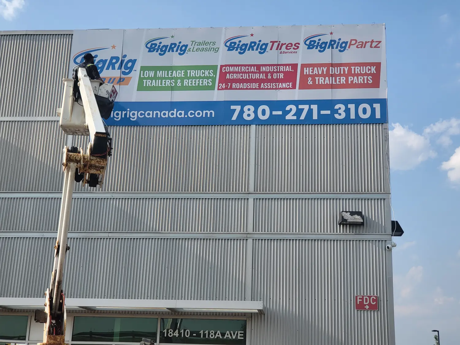 Bucket truck installing the BigRig Group fascia sign