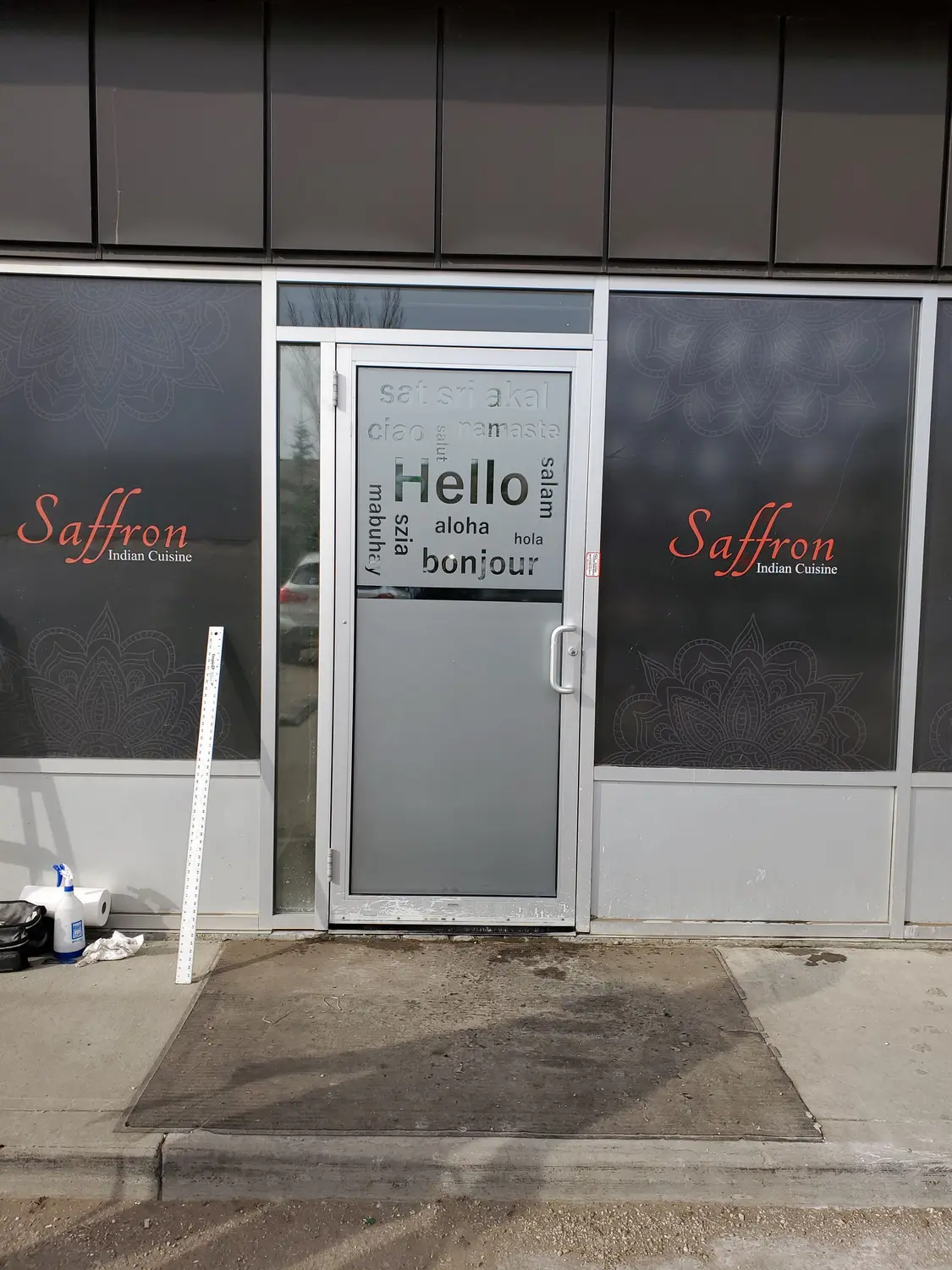 Saffron Indian Cuisine window graphics and frosted door with greetings in many languages
